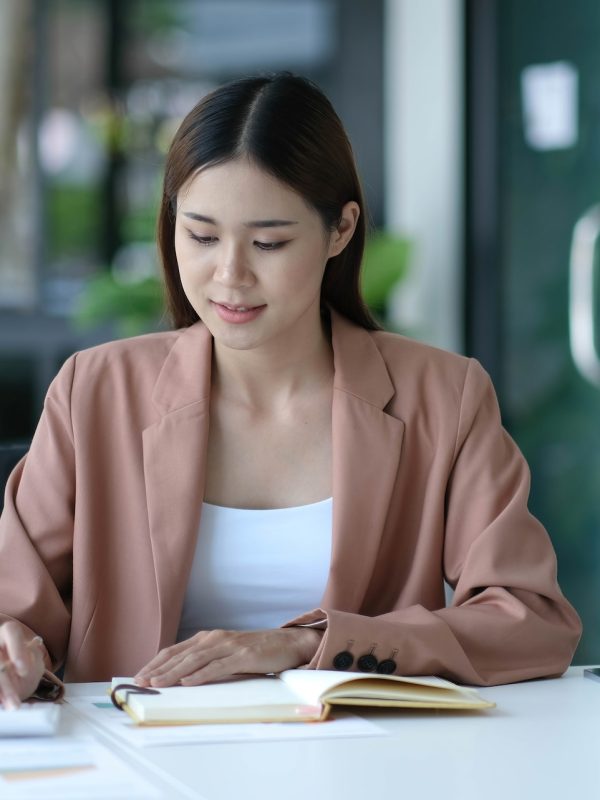 Business women using calculator at working with financial report.