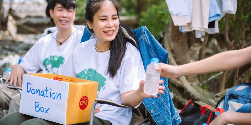 Group of asian diverse people volunteer holding a donation box for fundraiser to emergency situation