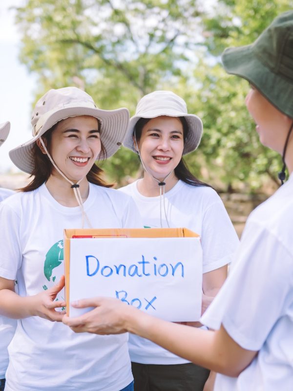 Group of Asian diverse people volunteer holding a donation box for World Environment Day campaign.