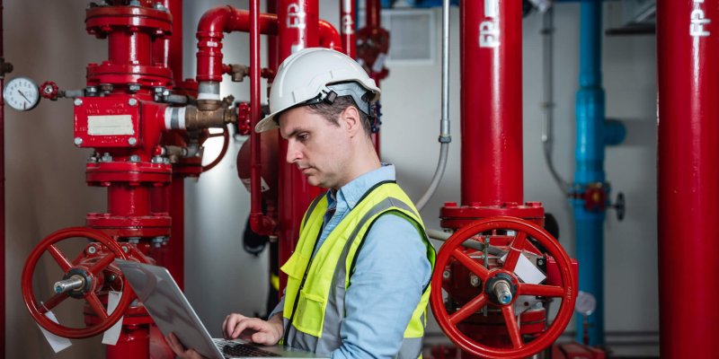 Engineers inspecting the inside plumbing and water valves of an industrial facility.