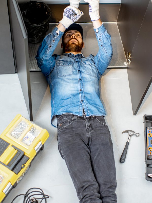 Man repairing kitchen plumbing