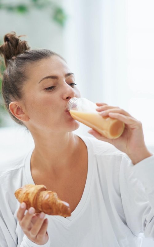 Young woman on bed with food catering box