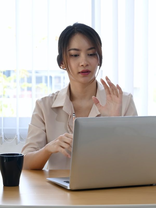 Young businesswoman using laptop computer virtual video conference with her business partner.