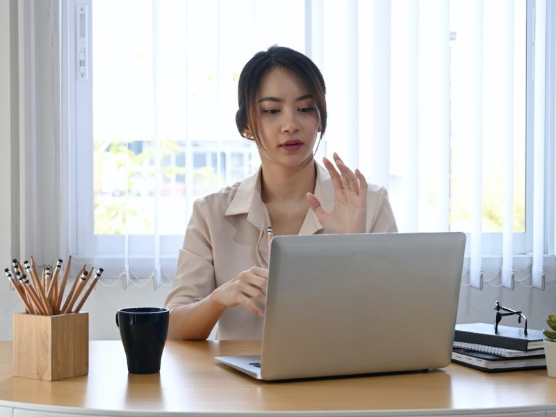 Young businesswoman using laptop computer virtual video conference with her business partner.