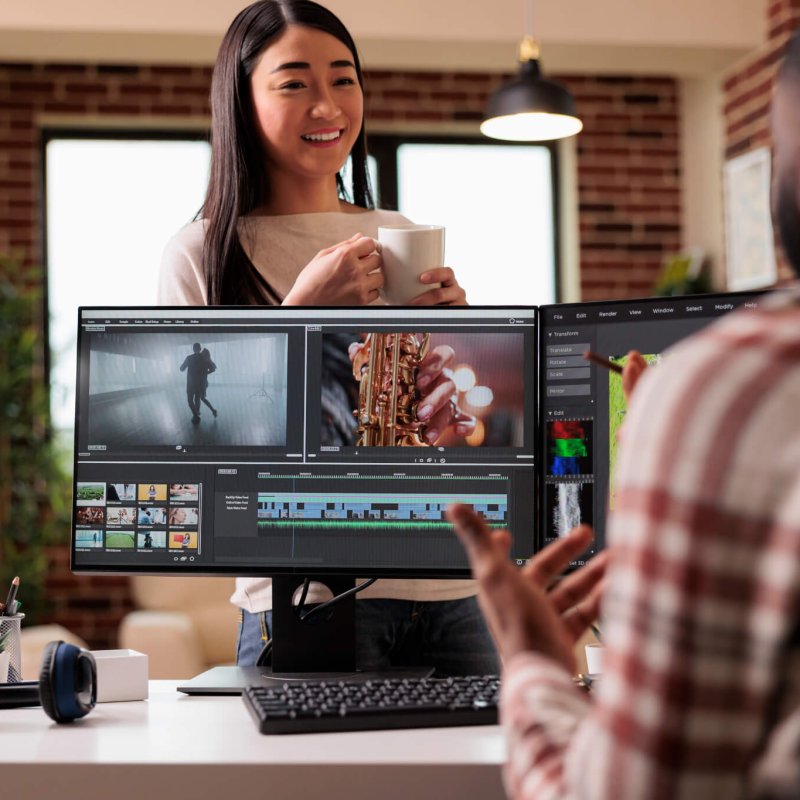People videographers editing film footage on computer