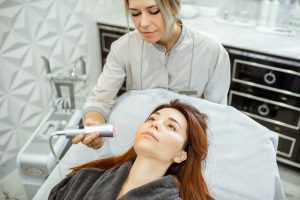 Cosmetologist making facial treatment to a woman