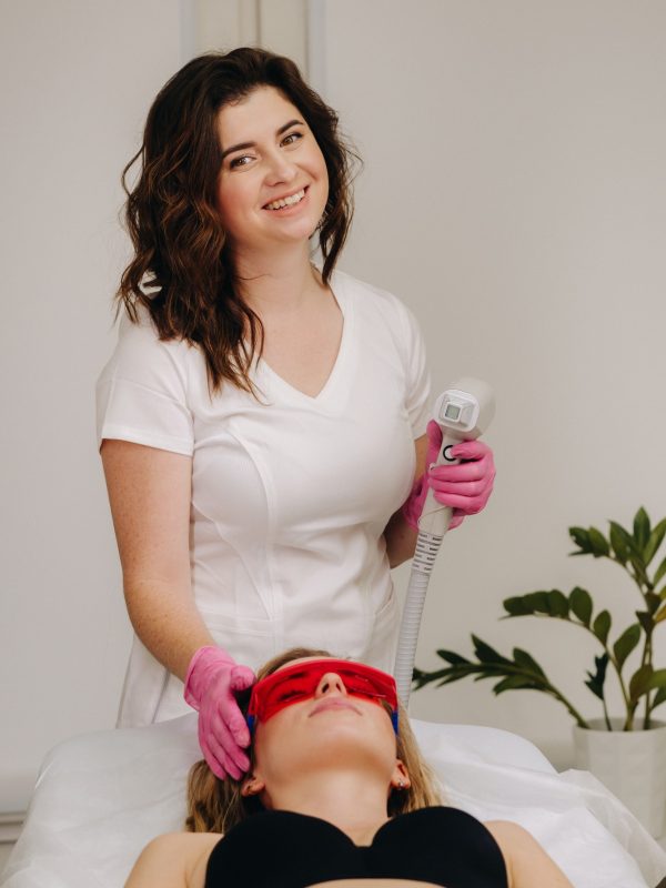 A doctor does laser hair removal for a client of unwanted facial hair in a beauty salon