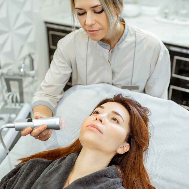 Cosmetologist making facial treatment to a woman